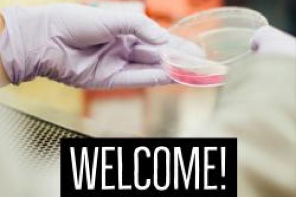 Image of hand holding petri dish with the text "welcome" included on picture